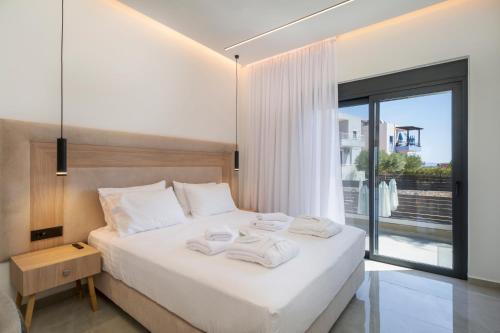 Un dormitorio con una cama blanca con toallas. en Luna Luxury Living, en Tavronitis