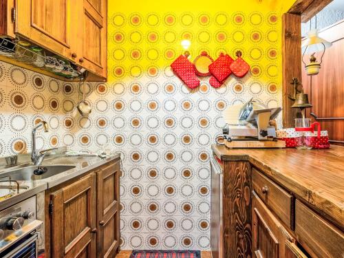 a kitchen with a yellow and white tiled wall at Apartment Pino Bianco by Interhome in Madesimo