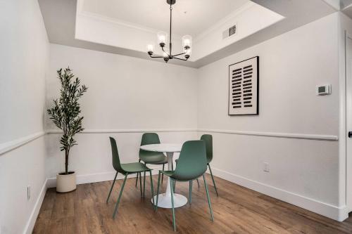 a dining room with a table and green chairs at Boulevard Stays Quiet Modern 2BR Pickleball Pool Parking Gym 05 in Chandler