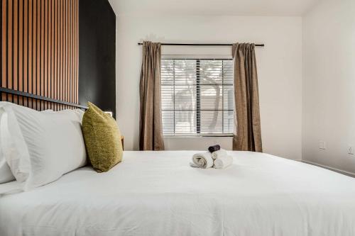 a bedroom with a large white bed with a window at Boulevard Stays Quiet Modern 2BR Pickleball Pool Parking Gym 05 in Chandler