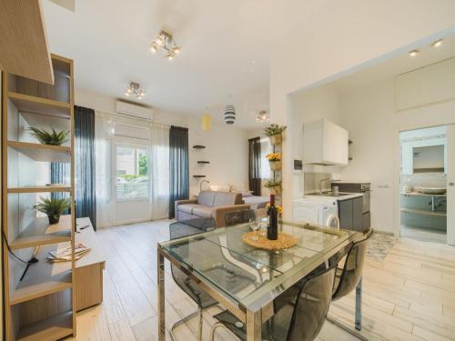 a living room with a glass table and a kitchen at Apartment Appartamento Lara by Interhome in Lido di Camaiore