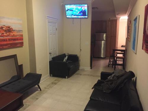 a living room with a couch and a tv on the wall at Mayflower Hospitality Hostel 2 in Washington, D.C.