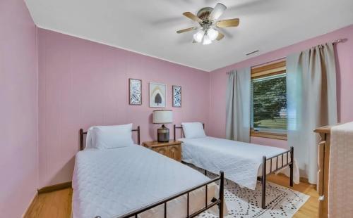 a bedroom with two beds and a ceiling fan at Cornerstone Cottage in Terre Haute