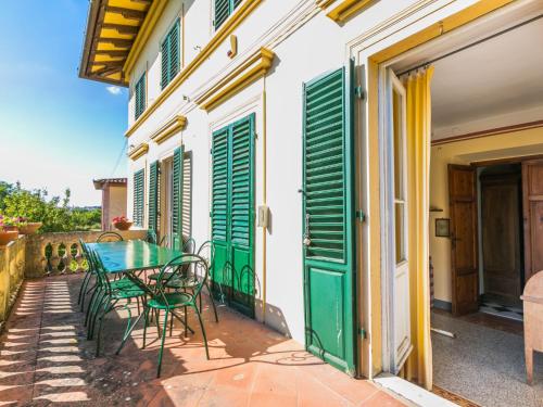 a patio with a green table and chairs on a building at Holiday Home Villa Mandri by Interhome in Castelfranco Piandisco