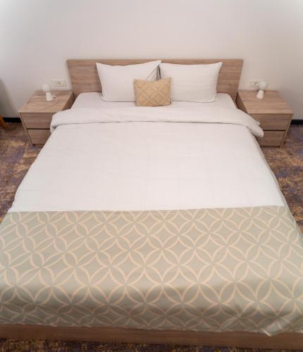 a bedroom with a large bed with two night stands at Casino Motel Senator in Gevgelija