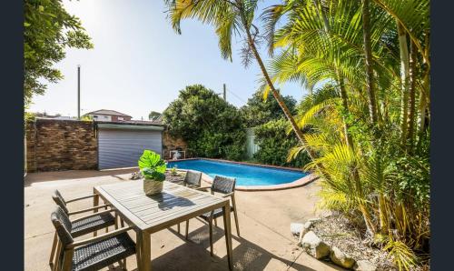 a patio with a table and chairs and a pool at Ground Level Apartment with Pool in Sydney