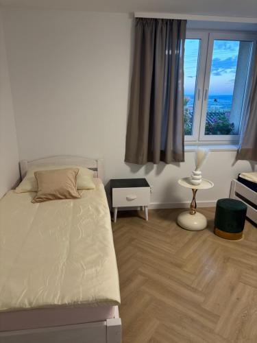 a bedroom with a bed and a large window at Apartament u Dyncyka in Krajno Pierwsze