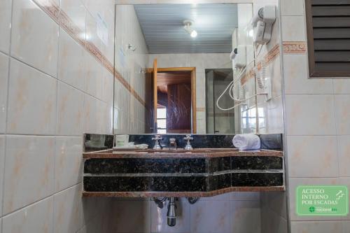 a bathroom with a sink and a mirror at Hotel Nacional Inn Campos do Jordão in Campos do Jordão