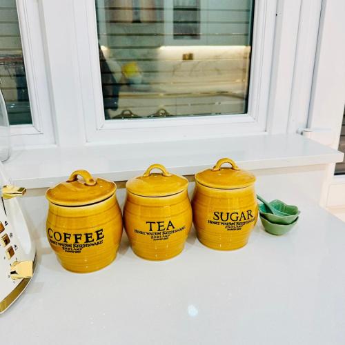 four yellow containers sitting on a counter in front of a window at Maple Grove - Luxury 1-Bedroom apartment with garden and parking in Greater London in Orpington