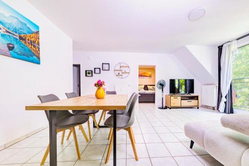 a dining room and living room with a table and chairs at Zentrales City Appartement Worms in Worms
