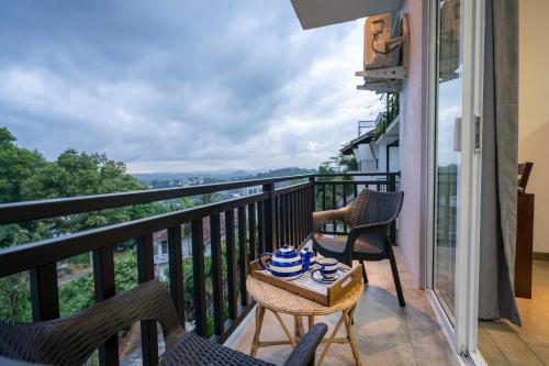- un balcon avec des chaises et une table avec un bol dans l'établissement Mo Green, à Kandy