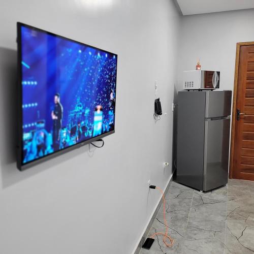 a flat screen tv hanging on a wall at Pousada Loft Marabá in Marabá