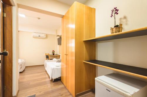 a small room with a bedroom and a bed at Itapetinga Hotel in Atibaia