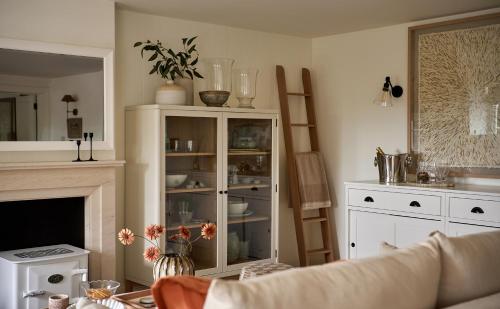 a living room with a white cabinet and a fireplace at Stretton Hills Peaks - The Georgian House in Ludlow