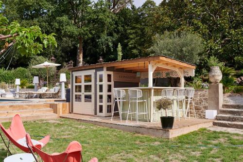 a gazebo with chairs and a bar in a yard at Villa Po'Strophe - Bâtiment classé avec piscine in Clisson