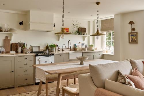 a kitchen and living room with a table and a couch at Stretton Hills Peaks - The Georgian House in Ludlow