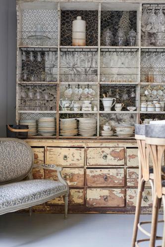 a wooden cabinet filled with dishes and bowls at Villa Po'Strophe - Bâtiment classé avec piscine in Clisson
