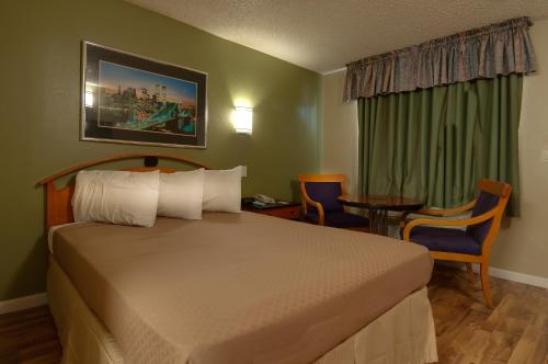 a hotel room with a bed and a table and chairs at Vagabond Inn Bakersfield North in Bakersfield