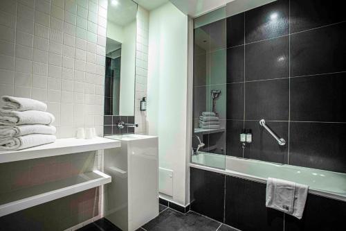 a bathroom with a tub and a sink and a shower at B&B HOME Brides-les-Bains Les 3 Vallées in Brides-les-Bains