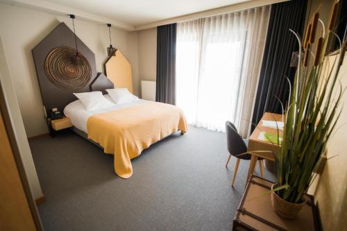 a hotel room with a bed and a window at ABCD - Hôtel-restaurant in Beauraing