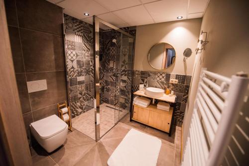 a bathroom with a shower and a toilet and a sink at ABCD - Hôtel-restaurant in Beauraing