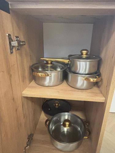 four pots and pans on a shelf in a kitchen at Apartament u Dyncyka in Krajno Pierwsze