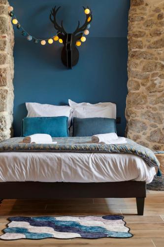 a bedroom with a bed with a blue wall at Villa Po'Strophe - Bâtiment classé avec piscine in Clisson