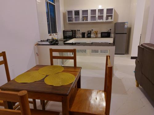 a kitchen with a table and chairs and a dining room at 2BR Beachfront Apartment with Balcony & Sea Views - Uroa, Zanzibar in Uroa