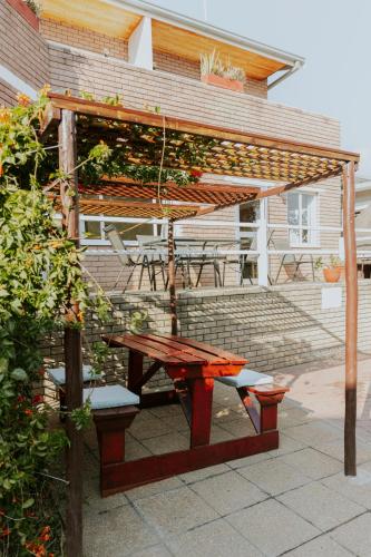 a picnic table and a pergola with a table and chairs at Hotel Uhland in Windhoek