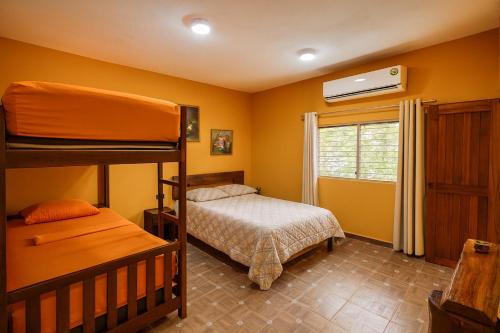 a bedroom with two bunk beds and a window at Yaxche Centro Hostal y Camping in Bacalar