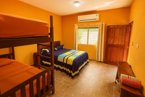 a bedroom with two bunk beds and a window at Yaxche Centro Hostal y Camping in Bacalar