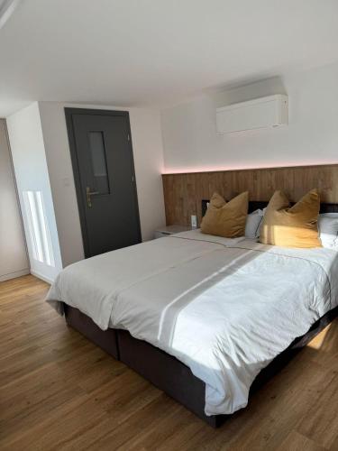 ein Schlafzimmer mit einem großen Bett mit weißen Laken und Kissen in der Unterkunft Oberbaar 7 in Baar