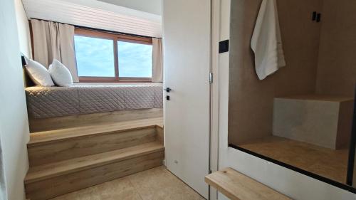 a small bedroom with a bed and a window at Andy's Place , Possidi By Halkidiki Villas in Possidi
