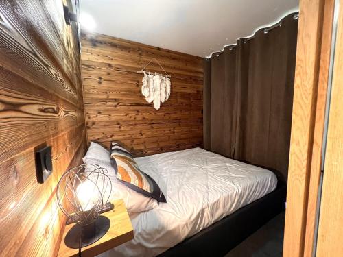 una piccola camera da letto con un letto e un tavolo di Chalet Détente a La Plagne Tarentaise