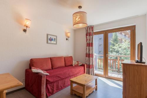 a living room with a red couch and a window at Résidence Odalys Pra Sainte Marie in Vars
