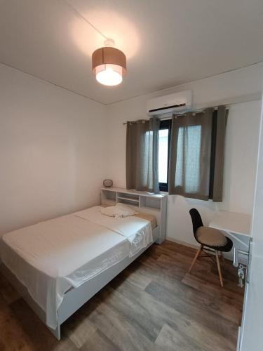 a bedroom with a bed and a desk and a chair at Kaz Koulèr in Saint-Denis