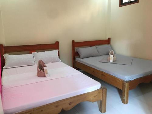 two beds in a room with two boxes on them at Jenises Inn in El Nido