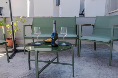 een fles wijn op een tafel met twee glazen bij Miramare Suites in Vasto