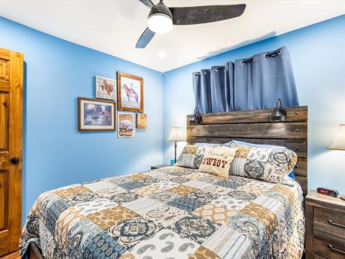 una camera da letto con un letto con pareti blu di Stockyards Longhorn House, TCU close by a Fort Worth