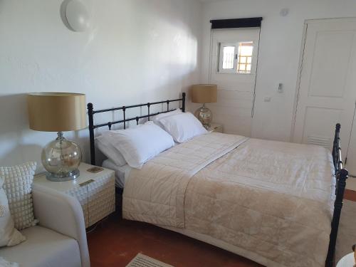 a bedroom with a bed and a couch and a chair at Casa Bella Studio in São Brás de Alportel