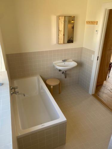 a bathroom with a bath tub and a sink at Løkkenshus Rooms and Apartments in the Heart of Løkken in Løkken
