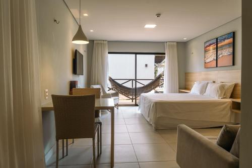 une chambre d'hôtel avec un lit, une table et des chaises dans l'établissement Apto 110 Taiti Villas BobZ, à Barrinha