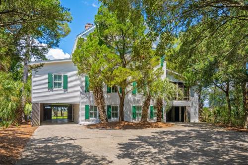 a white house with green shutters and trees at Kitchens Creek home by Peace Vacations in Georgetown