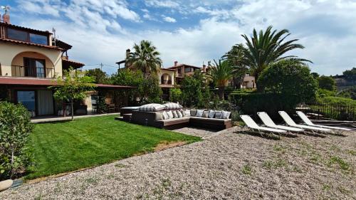 a yard with lounge chairs and a house at Andy's Place , Possidi By Halkidiki Villas in Possidi