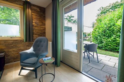a room with a door and two chairs and a table at Landgoedhotel Woodbrooke Barchem in Barchem