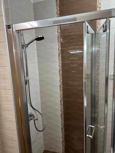 a shower in a bathroom with a glass door at Sunrise Apartment in Pomorie