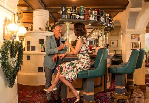 a man and a woman sitting at a bar at Hotel & Restaurant Wastlwirt in Sankt Michael im Lungau