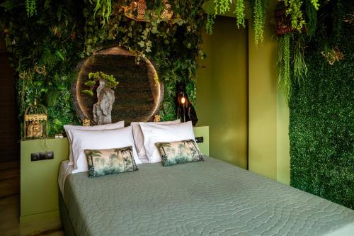 a bedroom with a bed with plants on the wall at Fairytale Athens Suites in Athens