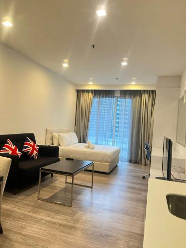 a living room with a couch and a table at Flexy Suite at One Bukit Ceylon Bukit Bintang in Kuala Lumpur