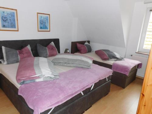 two beds in a room with purple sheets at Ostwind-ideal für Familien- in Ostermarkelsdorf